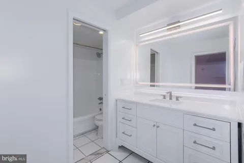 a bathroom with a double vanity sink toilet and mirror