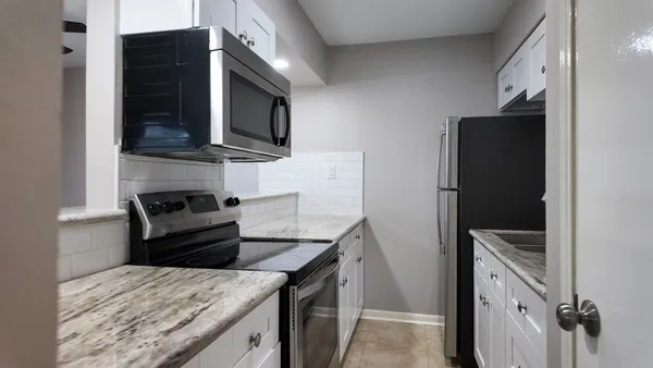 a kitchen with stainless steel appliances granite countertop a refrigerator and a stove