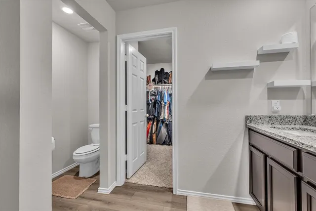 a view of a hallway with toilet and a view of bathroom