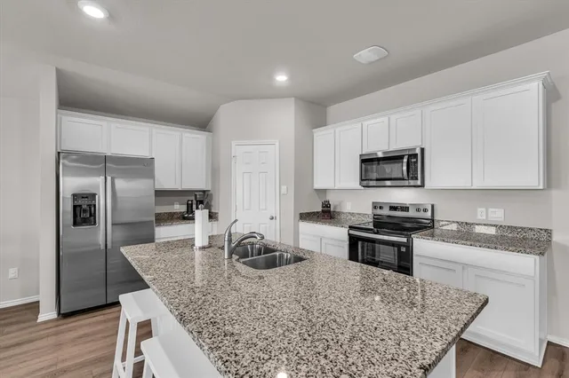 a kitchen with stainless steel appliances granite countertop a sink stove and refrigerator