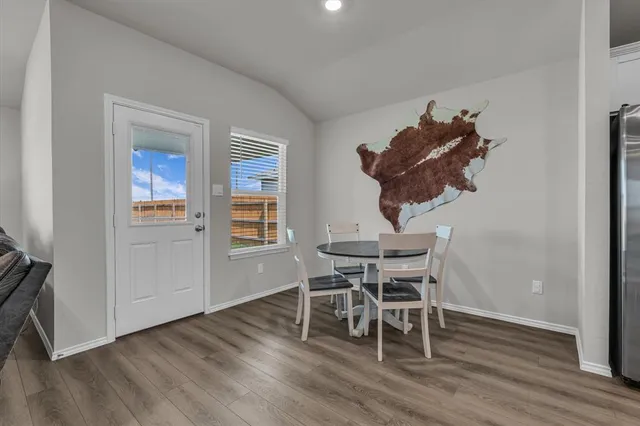 a dining room with furniture and wooden floor