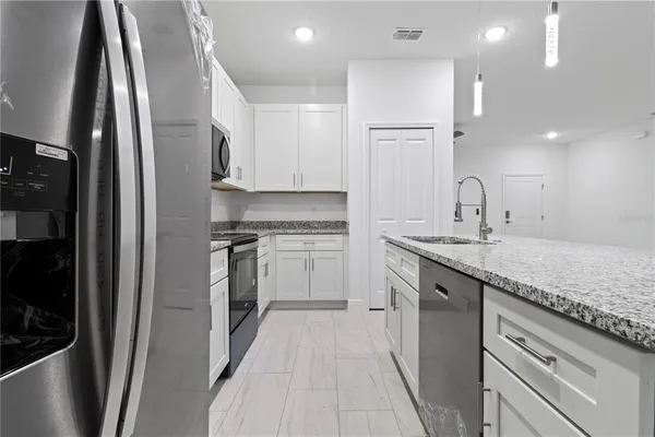 a kitchen with stainless steel appliances granite countertop a refrigerator and a sink