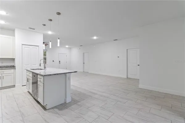 a kitchen with granite countertop a sink and a refrigerator