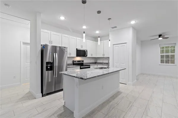 a kitchen with stainless steel appliances granite countertop a refrigerator and a stove