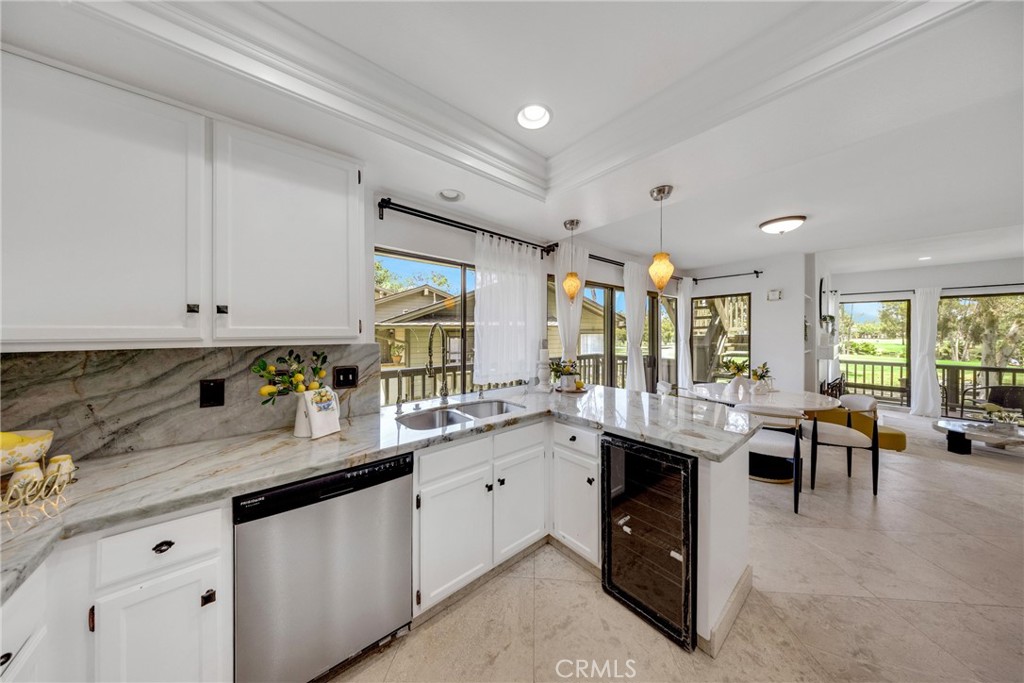 20 Nuevo, Unit 10 Irvine, CA 92612 - Photo 11 of 36 a large white kitchen with lots of counter space and chandelier