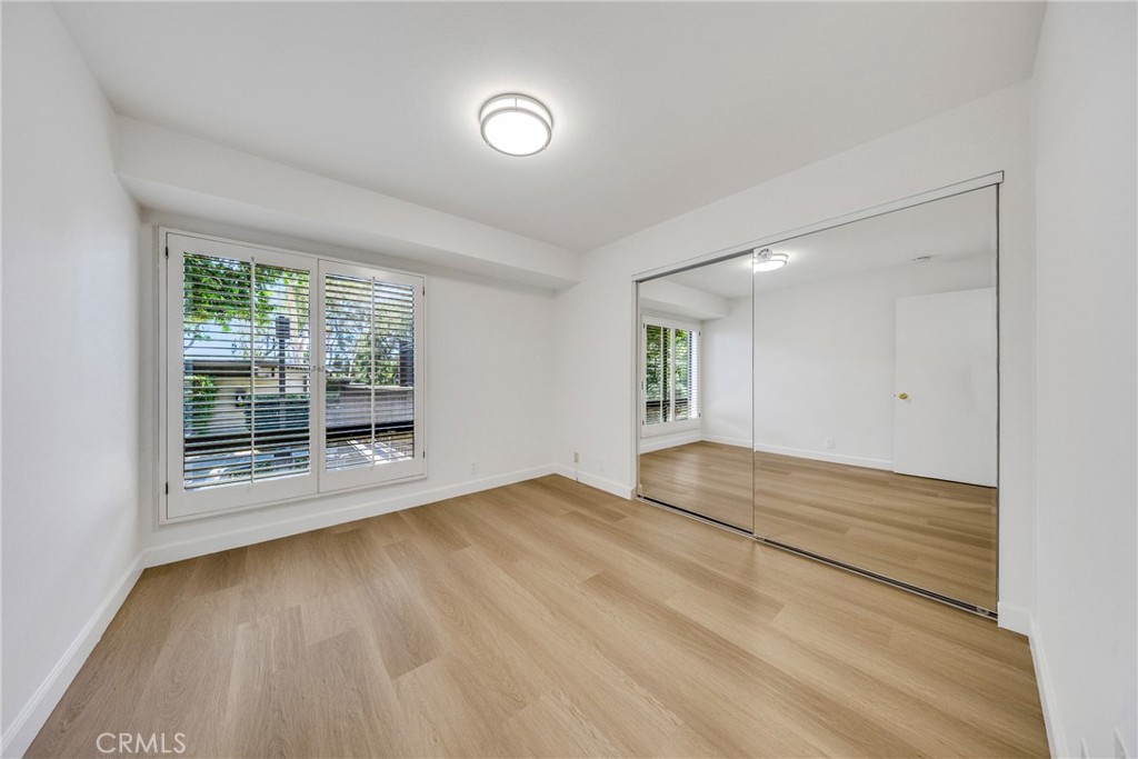 20 Nuevo, Unit 10 Irvine, CA 92612 - Photo 25 of 36 a view of an empty room with wooden floor and a window