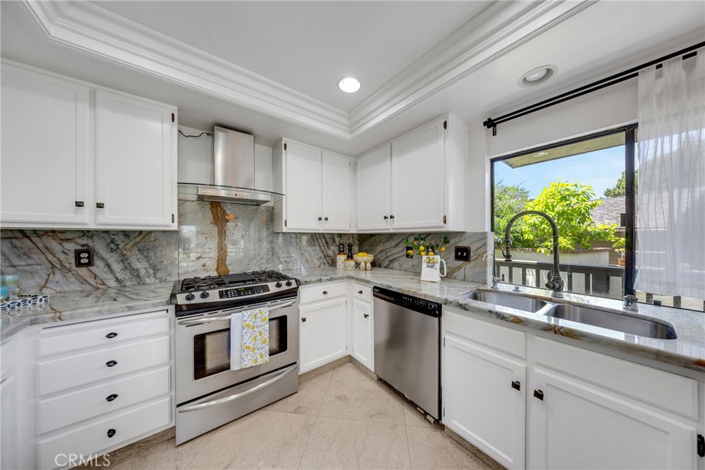 20 Nuevo, Unit 10 Irvine, CA 92612 - Photo 8 of 36 a kitchen with stainless steel appliances white cabinets and a stove top oven