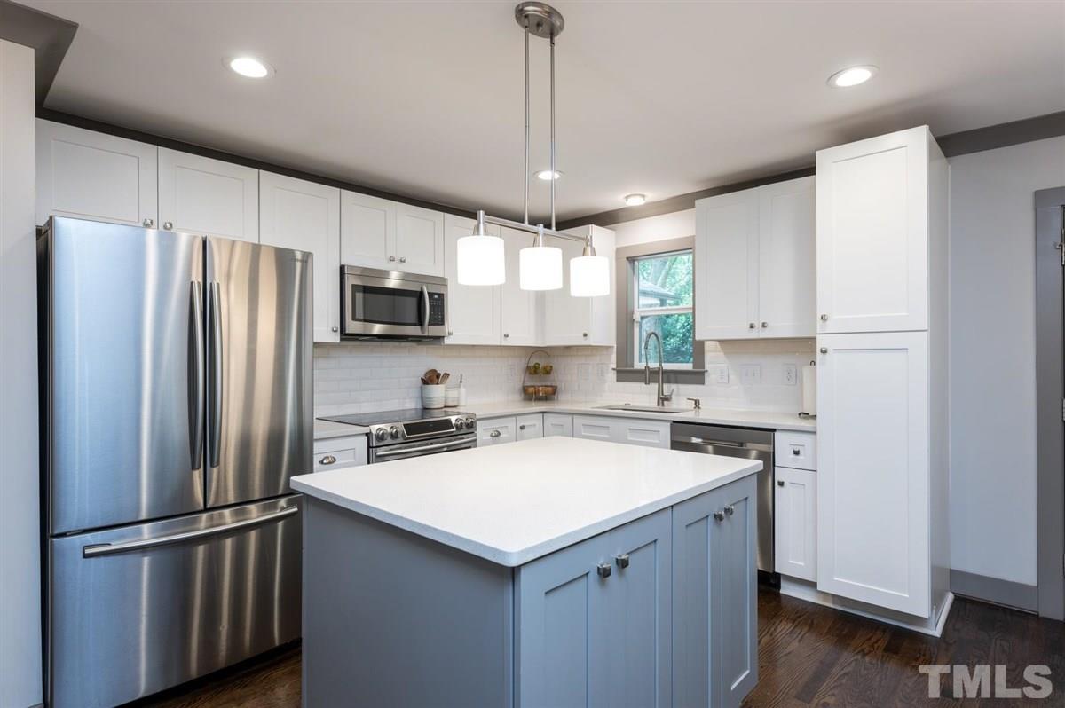 2446 Stevens Road Raleigh, NC 27610 - Photo 19 of 30 a kitchen with a refrigerator a sink a microwave and cabinets