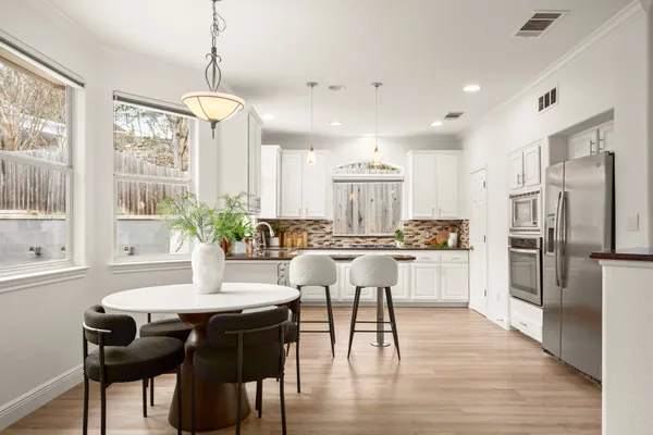 a kitchen with a table chairs refrigerator and cabinets
