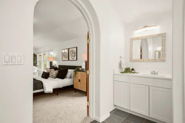 a spacious bathroom with a double vanity sink a large mirror and shower