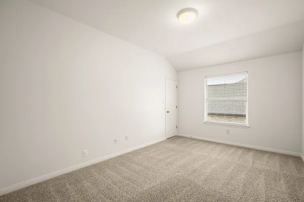 an empty room with a window and a ceiling fan
