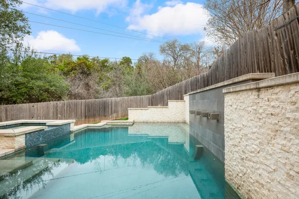 a view of a backyard with plants and a small pool