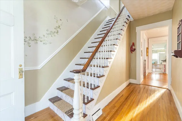 a view of staircase with white walls and wooden floor