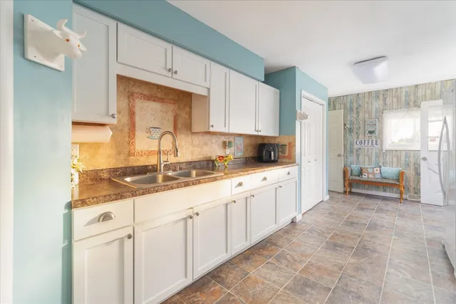 a kitchen with granite countertop a sink and white cabinets