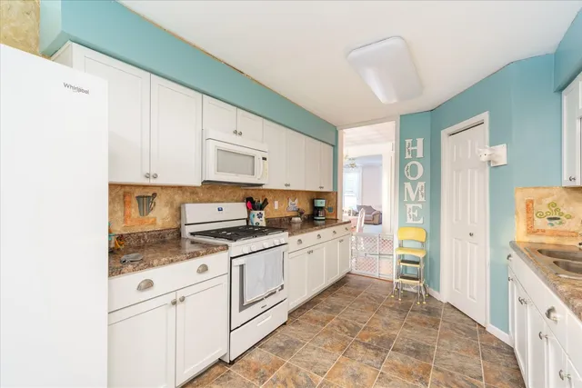 a kitchen with granite countertop white cabinets and stainless steel appliances