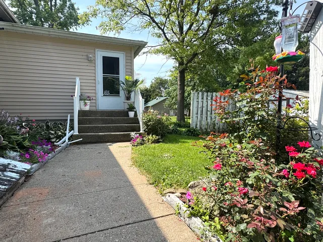 a small garden and flowers with wooden fence