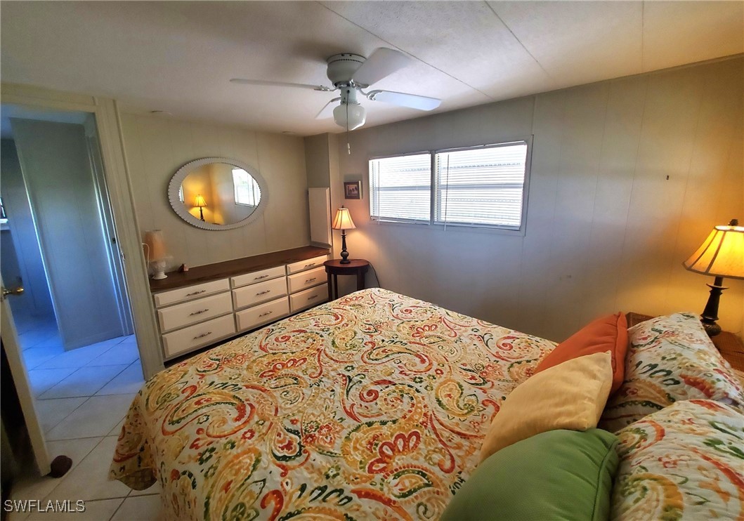 938 Lazy Lane North Fort Myers, FL 33917 - Photo 14 of 37 a bedroom with a bed and a lamp on the dresser