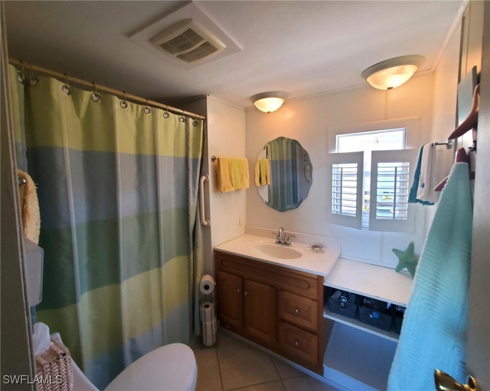 938 Lazy Lane North Fort Myers, FL 33917 - Photo 15 of 37 a bathroom with a double vanity sink toilet mirror and tub