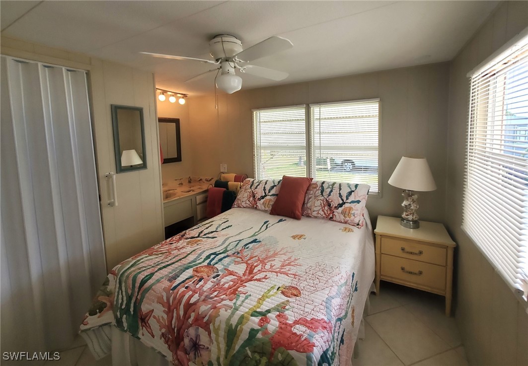 938 Lazy Lane North Fort Myers, FL 33917 - Photo 17 of 37 a bedroom with a bed and a chandelier