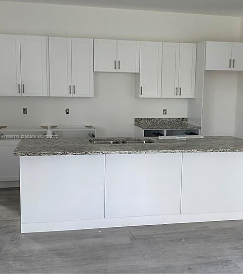 3911 Ordnance Road Lehigh Acres, FL 33971 - Photo 2 of 10 a kitchen with granite countertop white cabinets and white stainless steel appliances