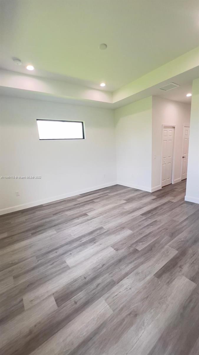 3911 Ordnance Road Lehigh Acres, FL 33971 - Photo 7 of 10 an empty room with wooden floor and windows