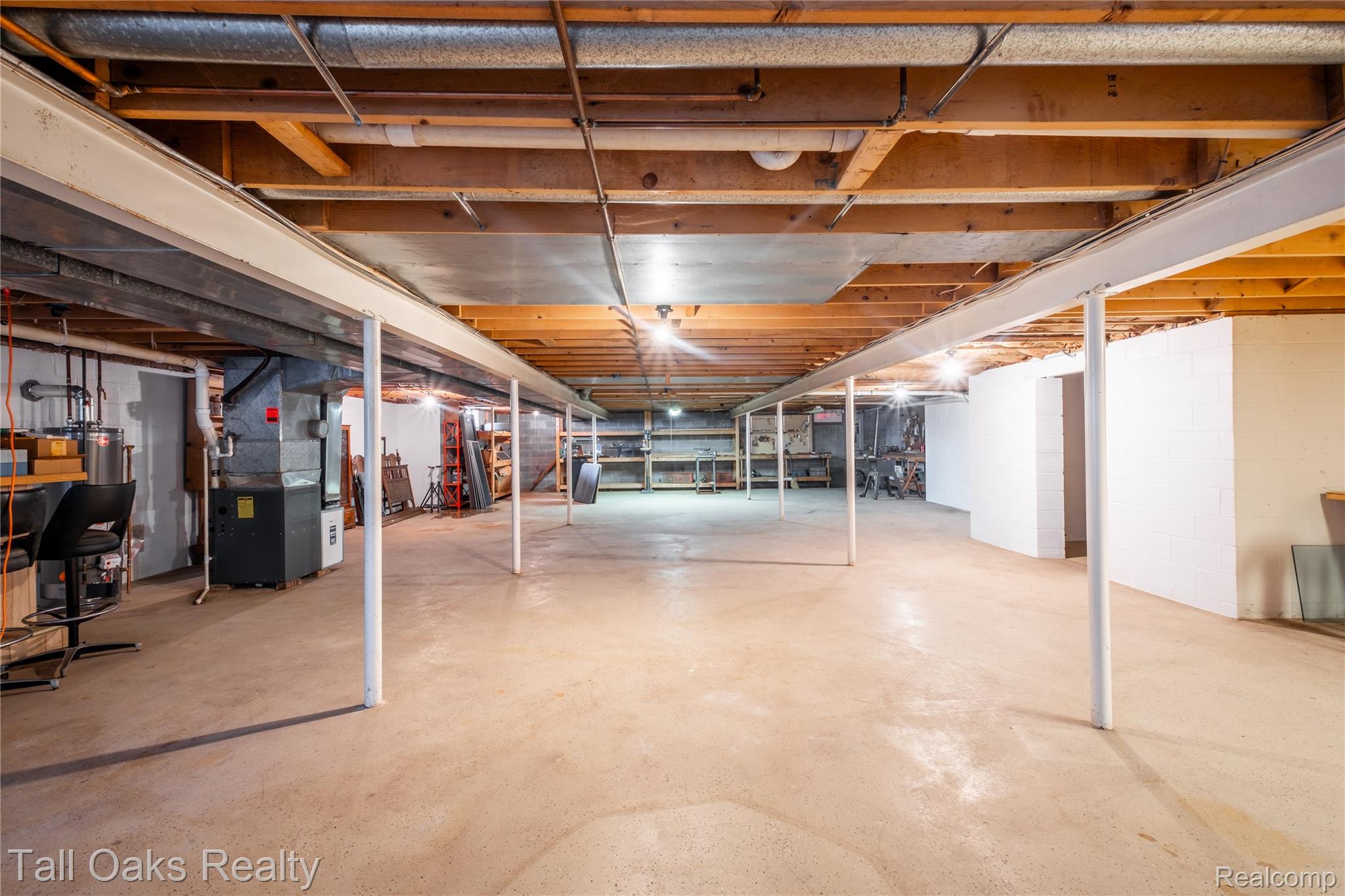 79330 Capac Road Armada, MI 48005 - Photo 39 of 42 Expansive unfinished basement featuring a concrete floor, exposed wood ceiling joists, and overhead lighting