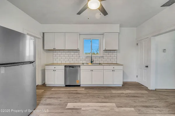 a kitchen with a refrigerator sink and cabinets