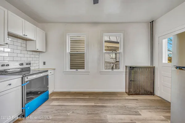 a view of kitchen with granite countertop cabinets appliances and a window