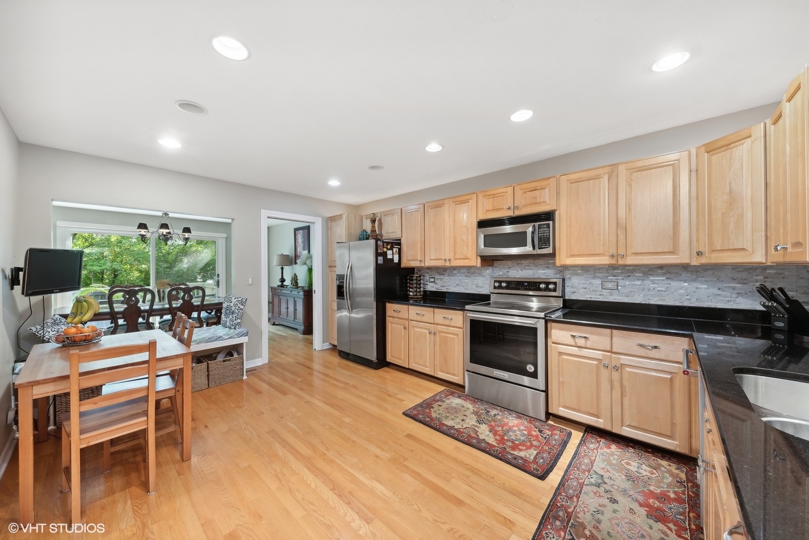 1483 West Shire Circle Inverness, IL 60067 - Photo 6 of 23 a kitchen with stainless steel appliances granite countertop a stove top oven a sink dishwasher a dining table and chairs with wooden floor