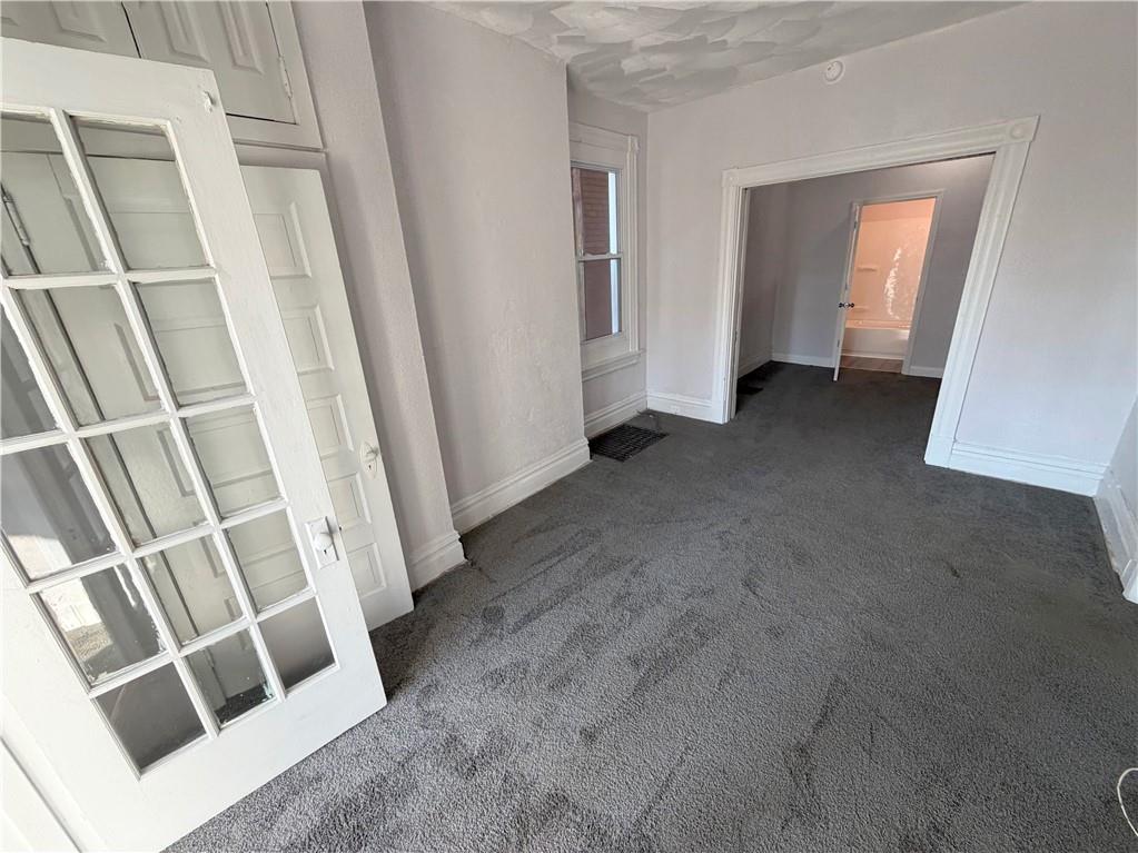 7709 Bennett Street, Unit 1 Pittsburgh, PA 15208 - Photo 3 of 6 a view of an empty room with wooden floor and stairs