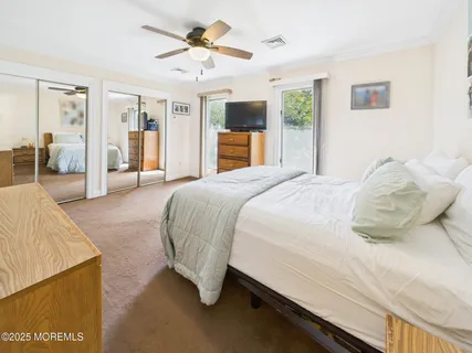 a spacious bedroom with a bed and a flat screen tv