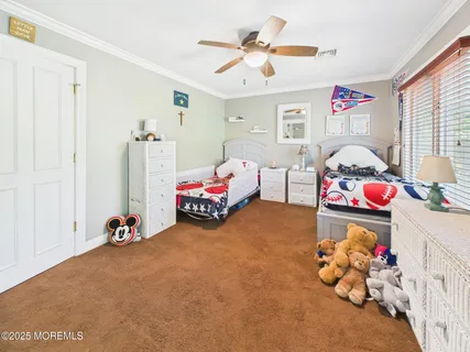 a bedroom with furniture and a chandelier fan