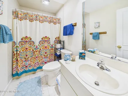 a bathroom with a sink toilet and shower curtain