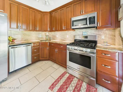 a kitchen with stainless steel appliances granite countertop a stove microwave and cabinets