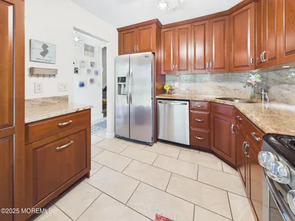 a kitchen with stainless steel appliances granite countertop a refrigerator and a sink