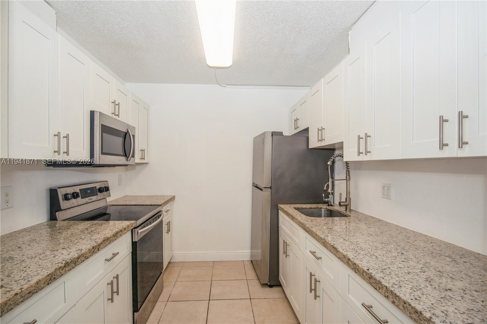 8200 Southwest 210th Street, Unit 111 Cutler Bay, FL 33189 - Photo 17 of 23 a kitchen with stainless steel appliances granite countertop a sink stove and refrigerator