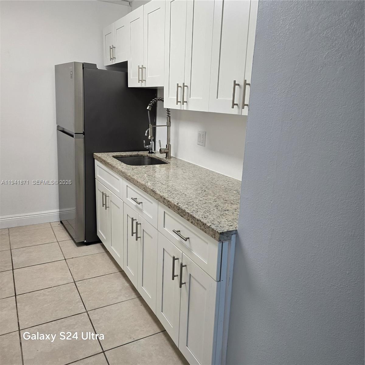 8200 Southwest 210th Street, Unit 111 Cutler Bay, FL 33189 - Photo 9 of 23 a kitchen with stainless steel appliances granite countertop a refrigerator and a stove
