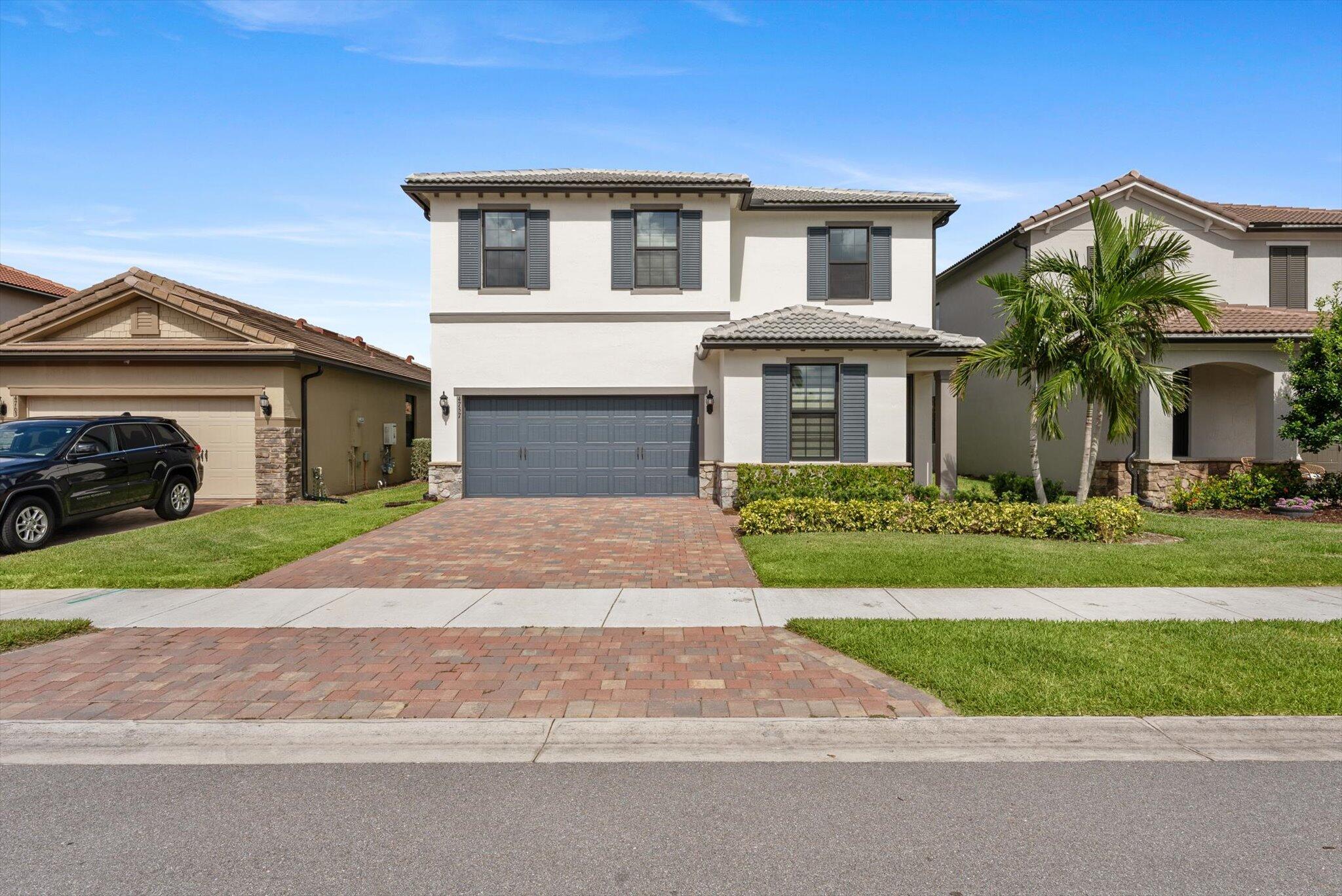 4757 Roldan Court, Unit ROLDAN CT Lake Worth, FL 33467 - Photo 2 of 37 a front view of a house with a yard and garage