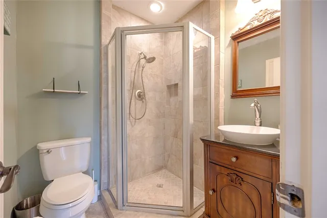 a bathroom with a granite countertop sink toilet and shower
