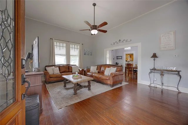 a living room with furniture a dining table and a chandelier