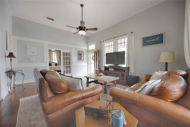a living room with furniture a flat screen tv and a window