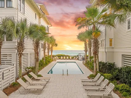 a view of a patio with a table and chairs potted plants and palm trees