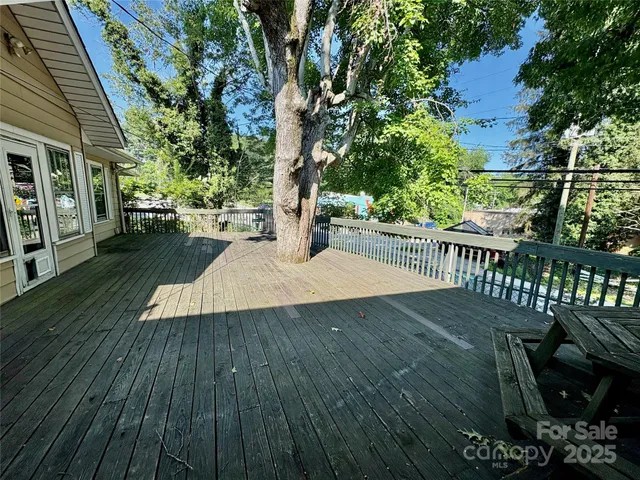 a view of a deck with a table and chairs with wooden floor and fence