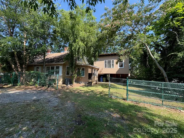 a view of a house with a yard patio and a tree