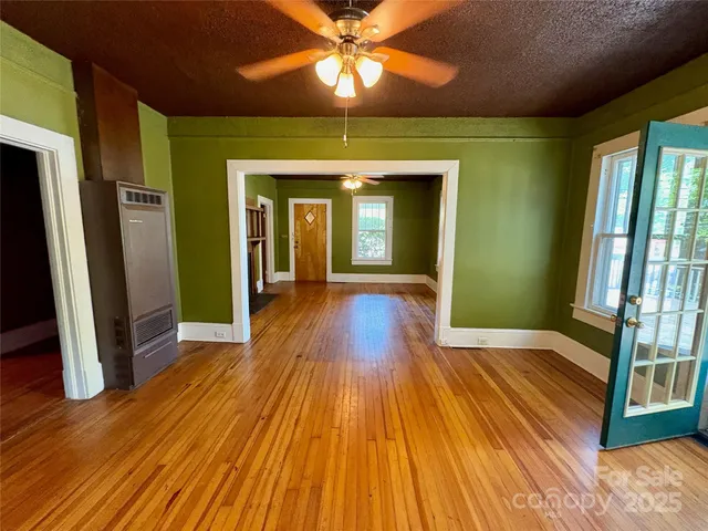 a view of a room with wooden floor and a chandelier