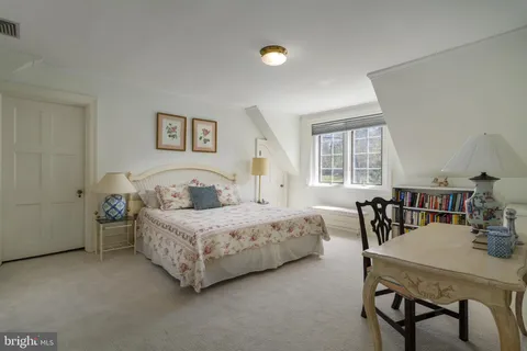 a bedroom with a bed a table and chairs