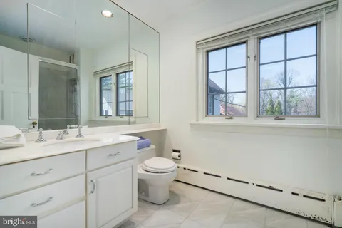 a bathroom with a toilet sink and mirror