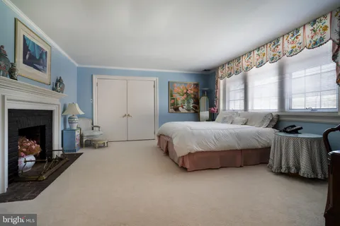 a spacious bedroom with a bed and a fireplace