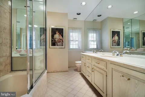 a spacious bathroom with a double vanity sink toilet and shower