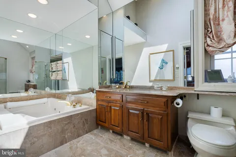 a bathroom with a granite countertop sink and a large mirror